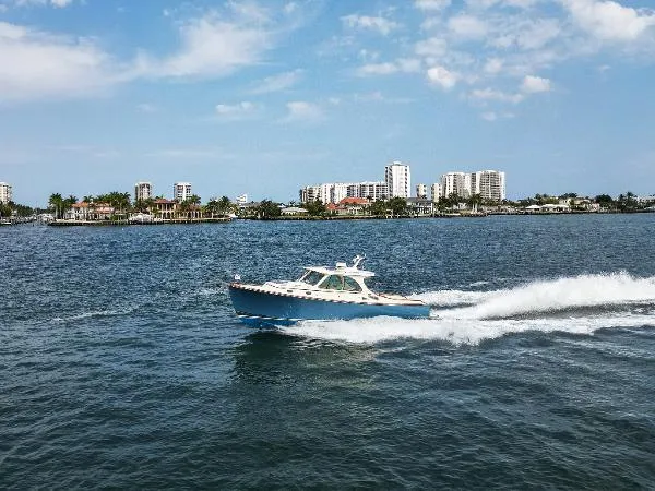  Yacht Photos Pics Hinckley Talaria 34 boat cruising on water with city skyline in background, 2013 model.