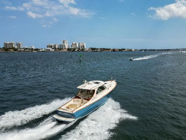  Yacht Photos Pics Hinckley Talaria 34 cruising on open water, city skyline in background, 2013 model.