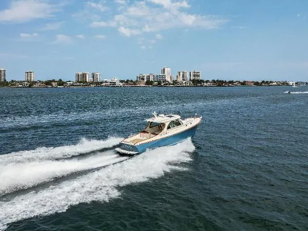  Yacht Photos Pics Hinckley Talaria 34 yacht cruising on open water, city skyline in background, 2013 model.