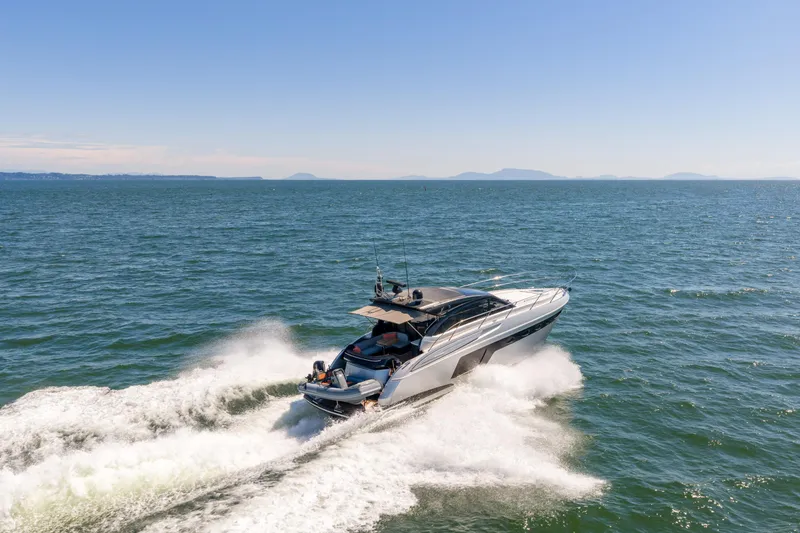 Yacht Photos Pics 2015 Princess V48 yacht cruising on open sea under clear blue sky.
