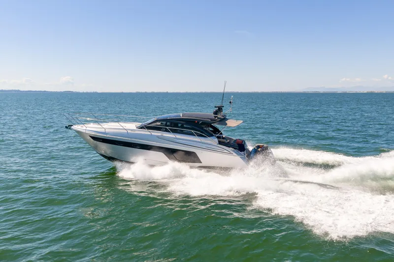  Yacht Photos Pics 2015 Princess V48 yacht cruising on open water under clear blue skies.