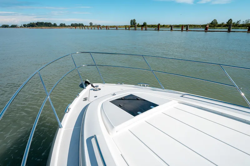  Yacht Photos Pics Bow view of 2015 Princess V48 yacht on calm water under clear blue sky.