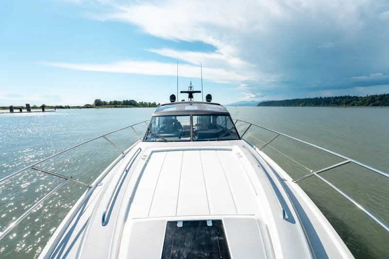  Yacht Photos Pics 2015 Princess V48 yacht cruising on a serene river under a clear blue sky.