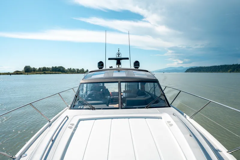  Yacht Photos Pics 2015 Princess V48 yacht cruising on a serene river under a clear blue sky.