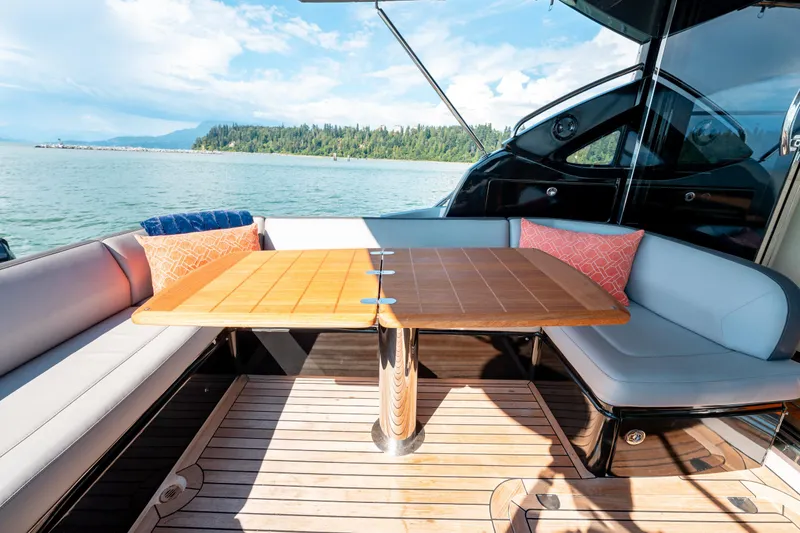  Yacht Photos Pics Luxurious 2015 Princess V48 yacht deck with seating and table, overlooking serene waters.