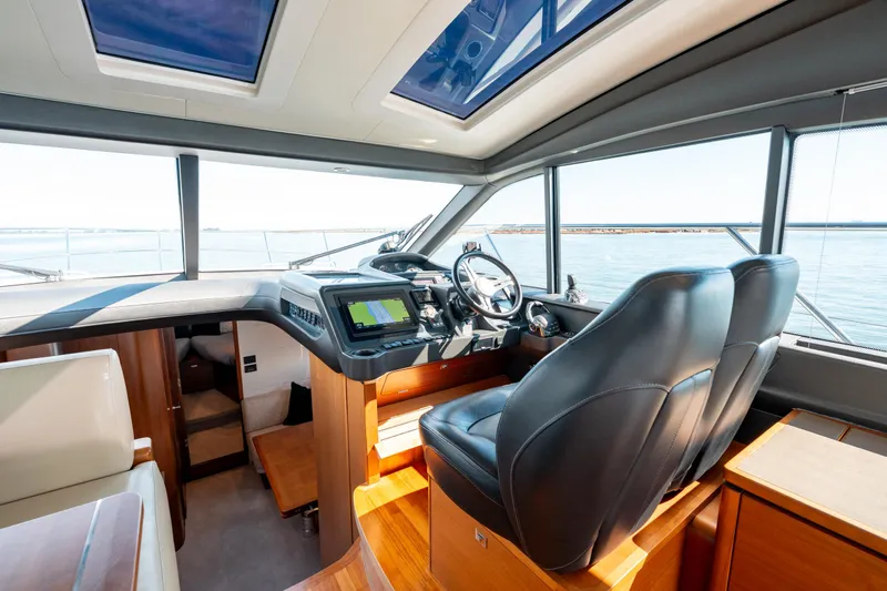  Yacht Photos Pics Interior of 2015 Princess V48 yacht cockpit with leather seats and navigation controls.