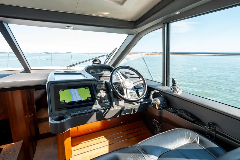  Yacht Photos Pics Interior view of 2015 Princess V48 yacht cockpit with navigation system and steering wheel.
