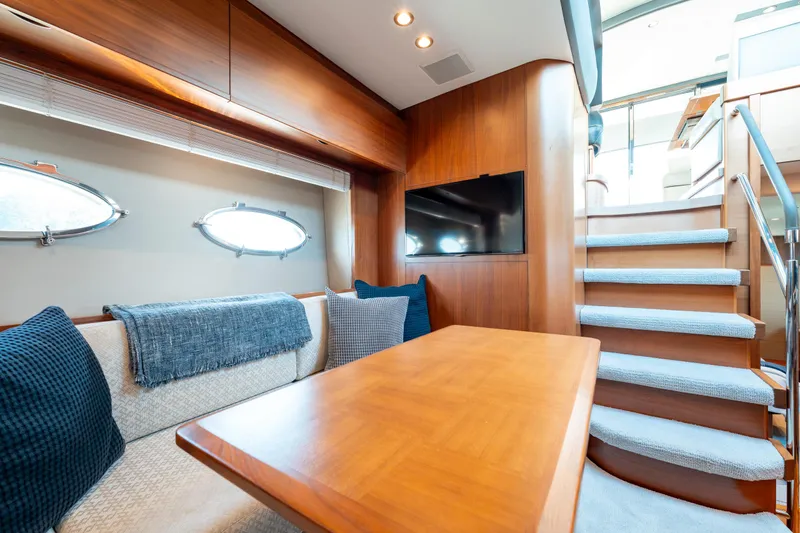  Yacht Photos Pics Luxurious interior of 2015 Princess V48 yacht with cozy seating and elegant wooden finishes.