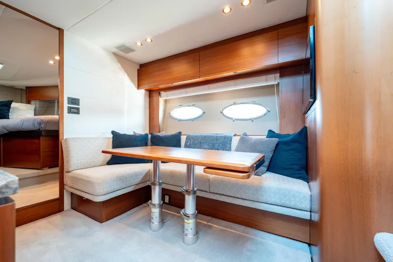  Yacht Photos Pics Luxurious interior of 2015 Princess V48 yacht with cozy seating and elegant wood finishes.