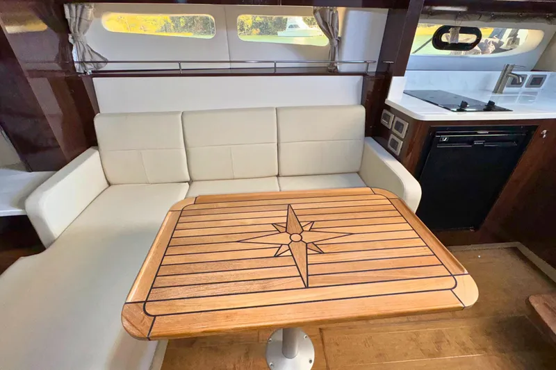  Yacht Photos Pics Interior of 2017 Sea Ray Sundancer 350 Coupe with elegant seating and wooden table.