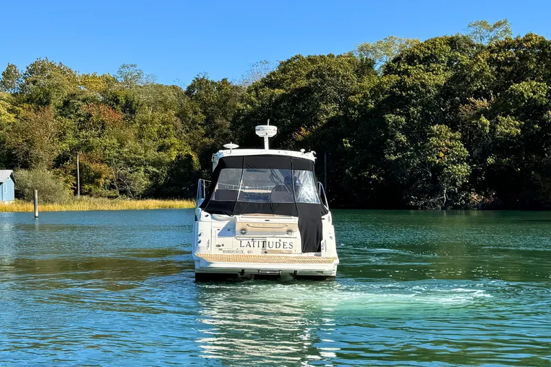  Yacht Photos Pics 2017 Sea Ray Sundancer 350 Coupe cruising on a serene lake with lush green trees.