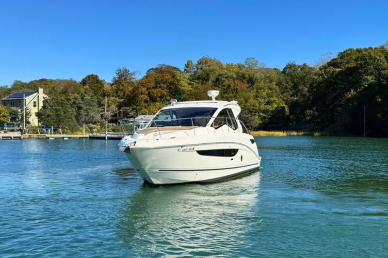  Yacht Photos Pics 2017 Sea Ray Sundancer 350 Coupe cruising on a serene lake with lush greenery.