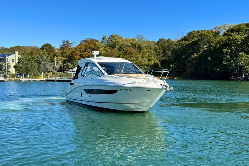  Yacht Photos Pics 2017 Sea Ray Sundancer 350 Coupe cruising on a serene lake with lush green surroundings.