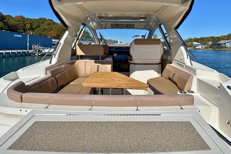  Yacht Photos Pics 2017 Sea Ray Sundancer 350 Coupe interior with seating and table, docked by the water.