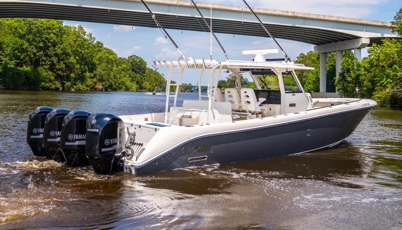  Yacht Photos Pics 2018 Everglades 435 Center Console boat cruising under a bridge on a river.