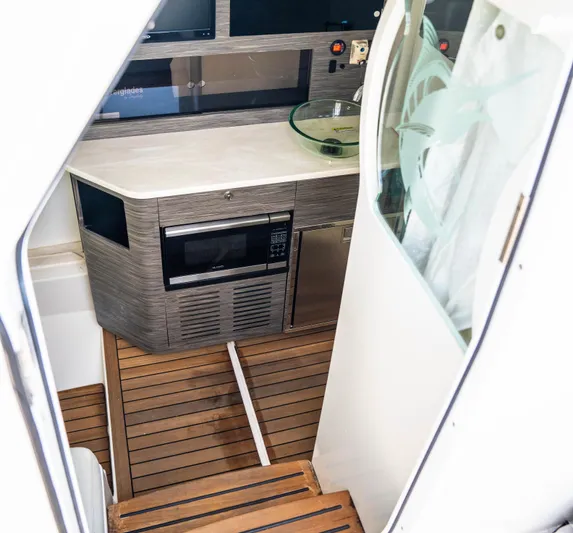  Yacht Photos Pics 2018 Everglades 435 Center Console interior with kitchenette and wooden flooring.