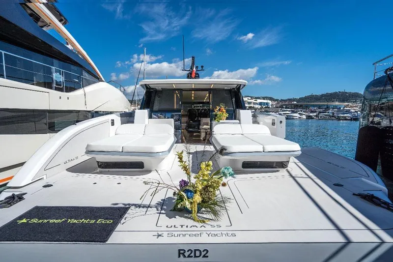 R2d2 Yacht Photos Pics Luxurious 2025 Sunreef 55 Ultima yacht docked, featuring elegant sunbeds and vibrant floral arrangements.
