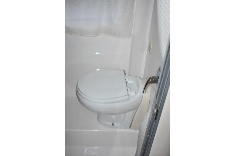  Yacht Photos Pics 2015 Regal 32 Express boat bathroom with white toilet and shower curtain.