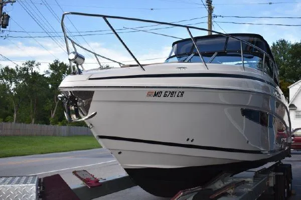  Yacht Photos Pics 2015 Regal 32 Express boat on trailer, parked near road, clear sky background.
