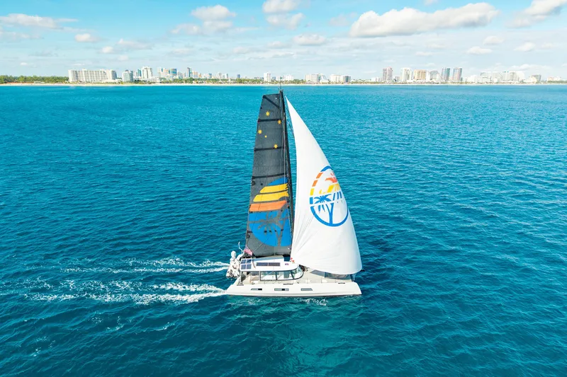 Crux Yacht Photos Pics Sailing yacht Harvey Yachts 58, 2017 model, cruising on clear blue ocean near city skyline.