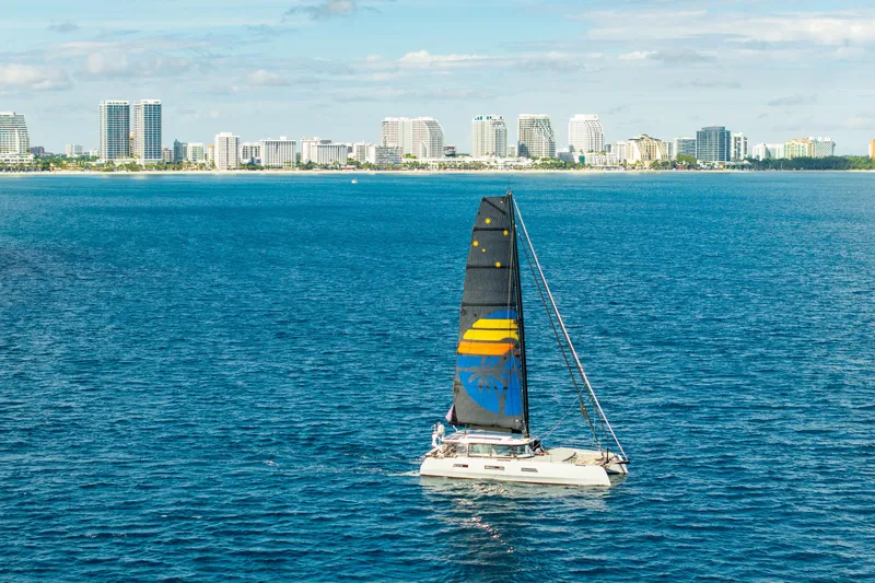 Crux Yacht Photos Pics Sailing yacht Harvey Yachts 58 (2017) on blue ocean with city skyline backdrop.