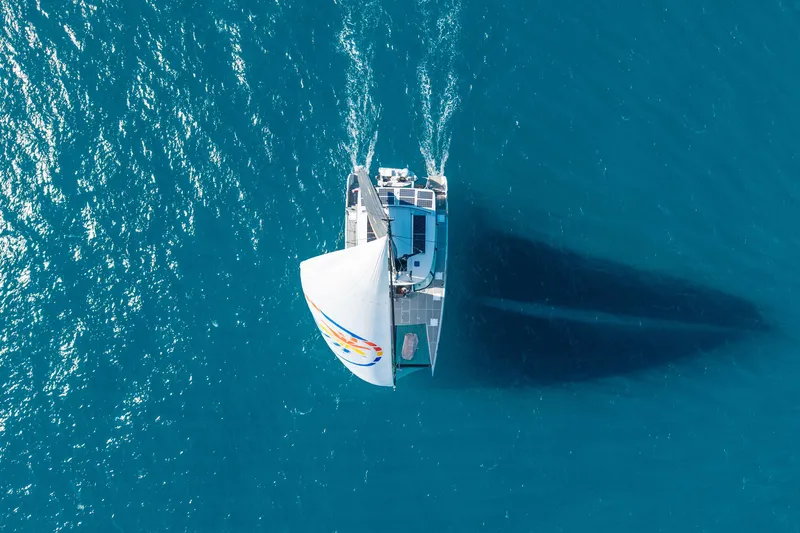 Crux Yacht Photos Pics Aerial view of 2017 Harvey Yachts 58 sailing on clear blue ocean waters.