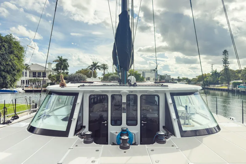 Crux Yacht Photos Pics 2017 Harvey Yachts 58 docked, showcasing sleek design and spacious deck under a cloudy sky.