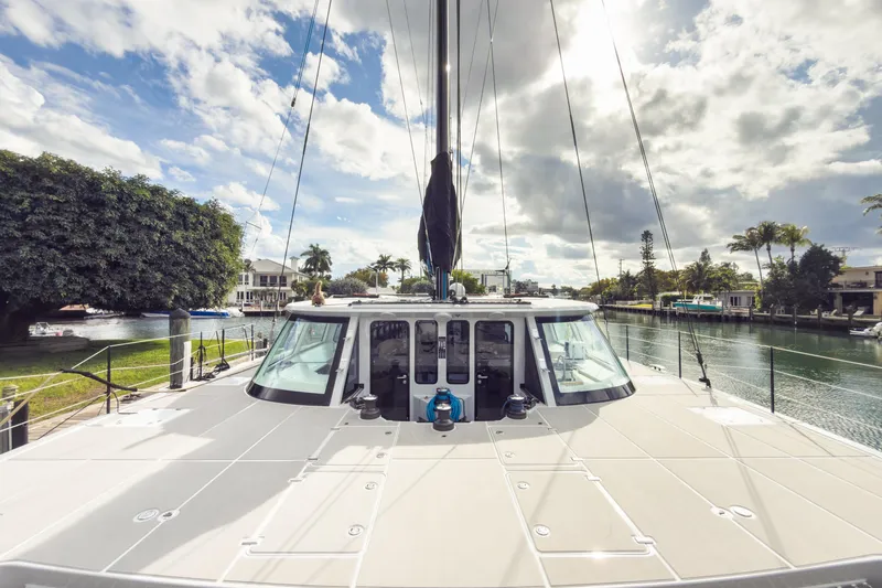 Crux Yacht Photos Pics 2017 Harvey Yachts 58 docked by a scenic canal under a partly cloudy sky.