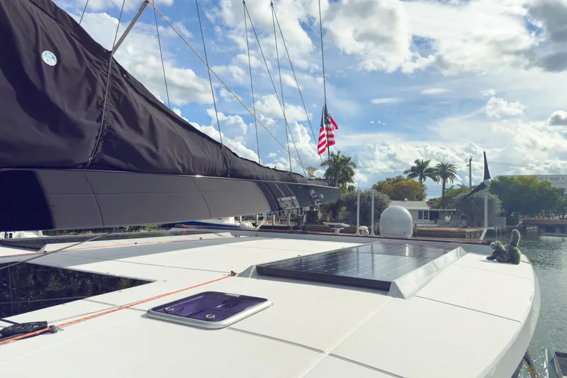 Crux Yacht Photos Pics 2017 Harvey Yachts 58 sailboat with solar panel, docked under a partly cloudy sky.