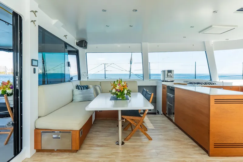 Crux Yacht Photos Pics Luxurious interior of 2017 Harvey Yachts 58, featuring modern kitchen and dining area with ocean view.