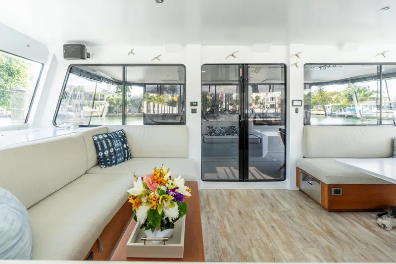 Crux Yacht Photos Pics Luxurious interior of 2017 Harvey Yachts 58, featuring elegant seating and floral centerpiece.