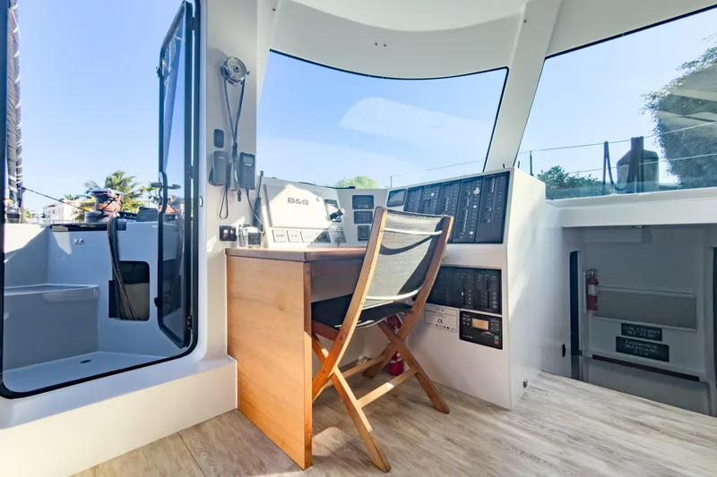 Crux Yacht Photos Pics Modern helm station of 2017 Harvey Yachts 58 with navigation equipment and wooden chair.