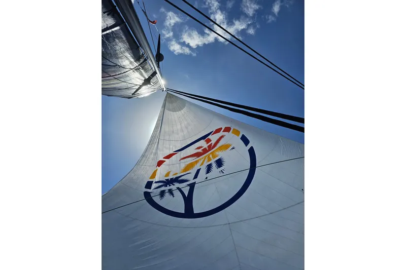 Crux Yacht Photos Pics Sail of 2017 Harvey Yachts 58 against blue sky, featuring colorful logo design.