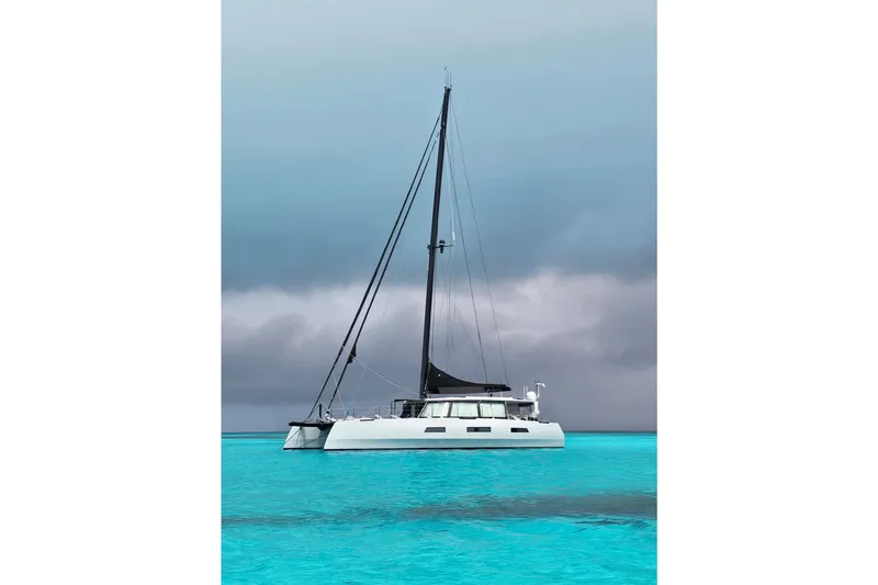 Crux Yacht Photos Pics Sleek 2017 Harvey Yachts 58 catamaran on turquoise waters under cloudy skies.