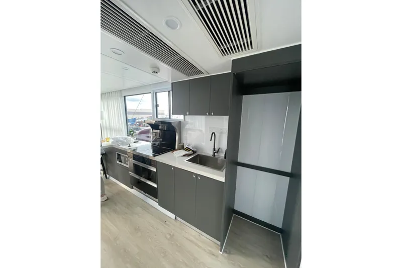  Yacht Photos Pics Modern kitchen interior on 2025 Houseboat ALLHOUSE HB-1250, featuring sleek cabinetry and appliances.