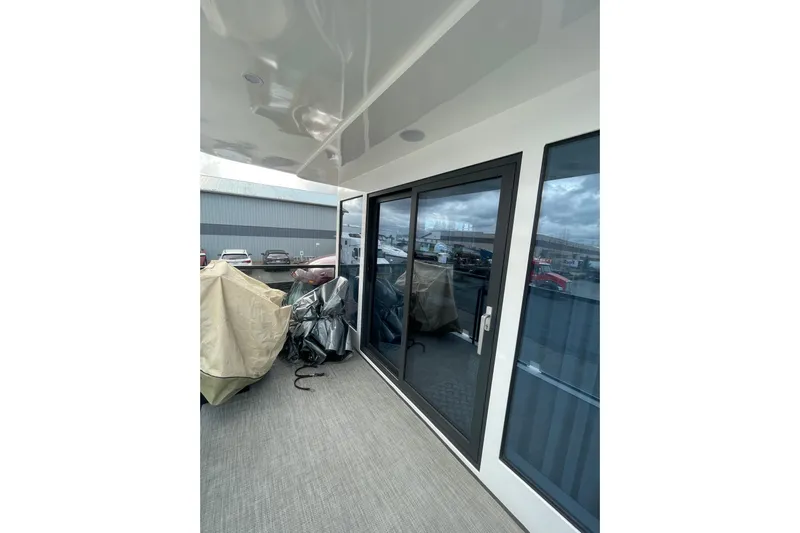  Yacht Photos Pics Modern 2025 Houseboat ALLHOUSE HB-1250 with sleek glass doors and covered outdoor area.