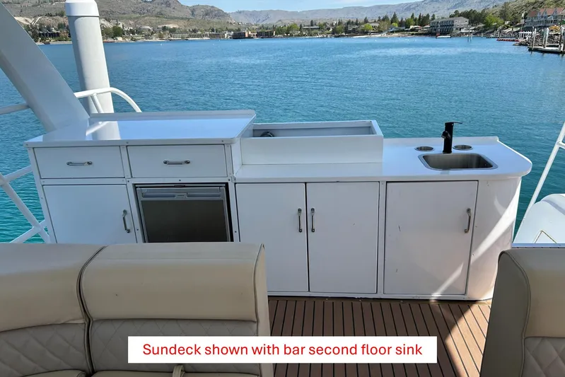  Yacht Photos Pics Houseboat sundeck with bar and sink, overlooking serene blue waters, 2025 model.
