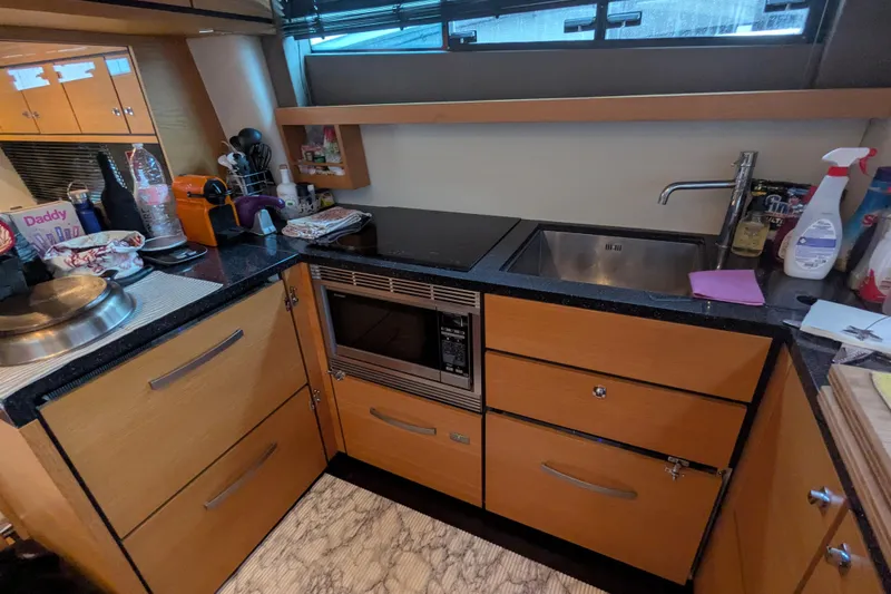  Yacht Photos Pics Modern kitchen in 2009 Fairline Squadron 55 yacht with sink, stove, and microwave.