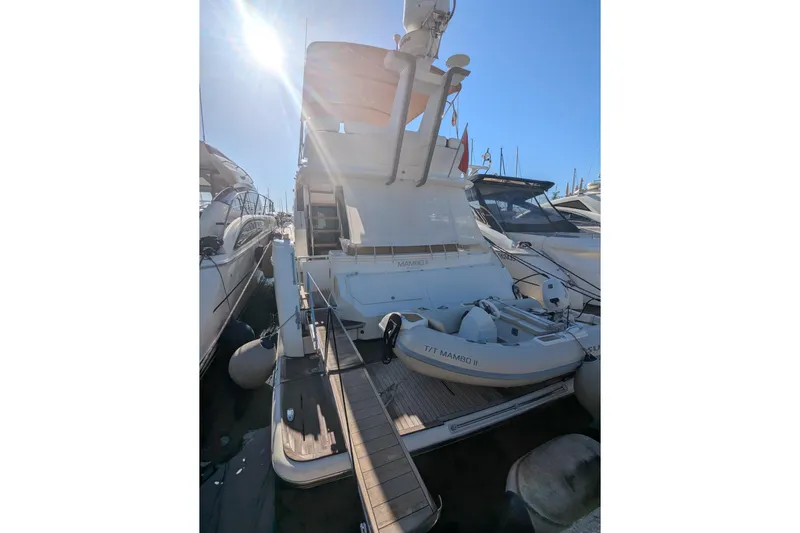  Yacht Photos Pics 2009 Fairline Squadron 55 yacht docked with inflatable boat, under bright sunlight.