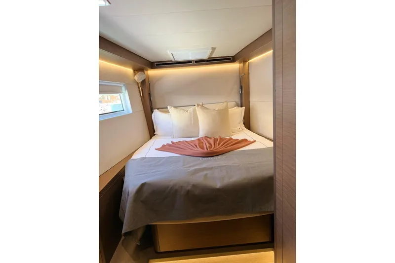  Yacht Photos Pics Luxurious cabin interior of 2020 Lagoon 50 yacht with cozy bed and ambient lighting.