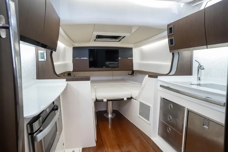 4 Reels Yacht Photos Pics Interior of 2021 Grady-White Canyon 456 boat with modern kitchen and seating area.