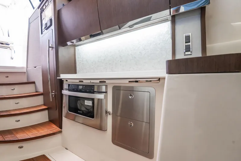 4 Reels Yacht Photos Pics 2021 Grady-White Canyon 456 interior with modern kitchen and wooden stairs.