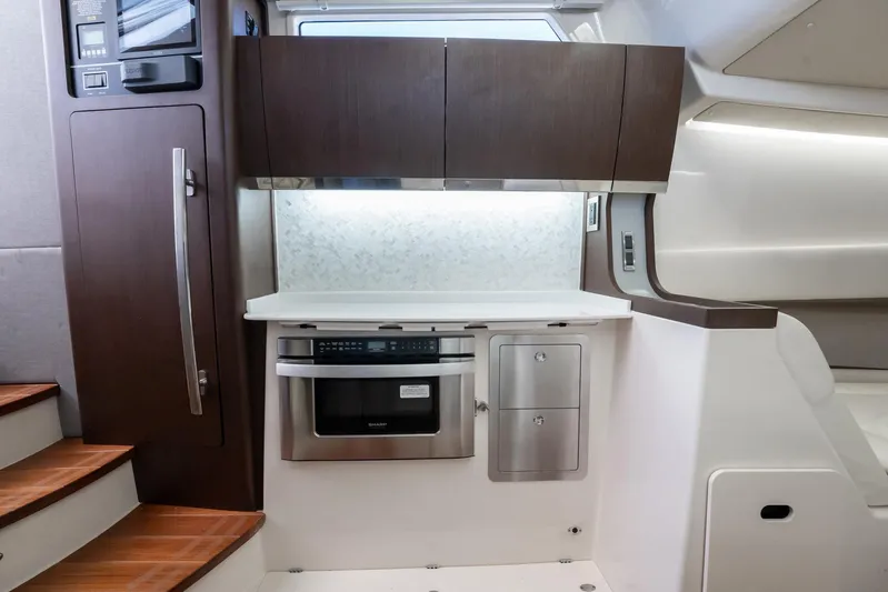 4 Reels Yacht Photos Pics Modern kitchen area in 2021 Grady-White Canyon 456 boat, featuring sleek cabinetry and appliances.