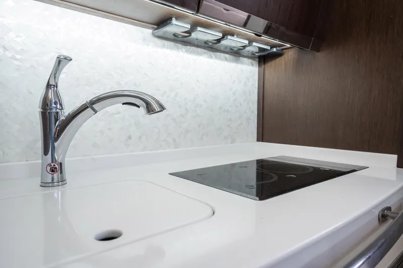 4 Reels Yacht Photos Pics Modern kitchen area in 2021 Grady-White Canyon 456 boat with sleek faucet and cooktop.
