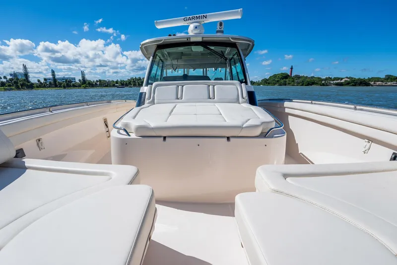 4 Reels Yacht Photos Pics 2021 Grady-White Canyon 456 boat on water, featuring spacious seating and clear skies.
