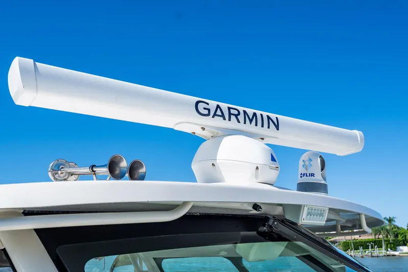 4 Reels Yacht Photos Pics 2021 Grady-White Canyon 456 boat with Garmin radar and FLIR system under clear blue sky.