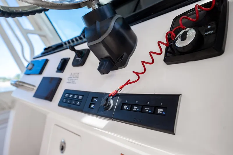 4 Reels Yacht Photos Pics Control panel of 2021 Grady-White Canyon 456 boat with steering wheel and switches.