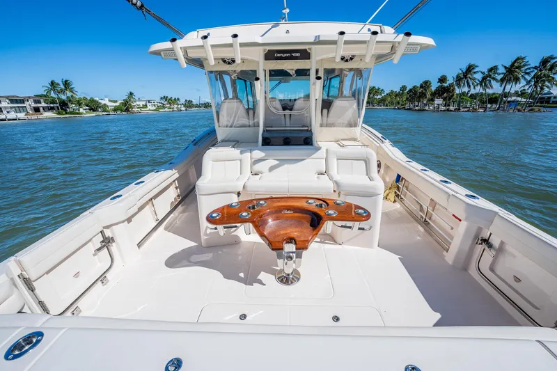 4 Reels Yacht Photos Pics 2021 Grady-White Canyon 456 boat on water, featuring spacious deck and seating.
