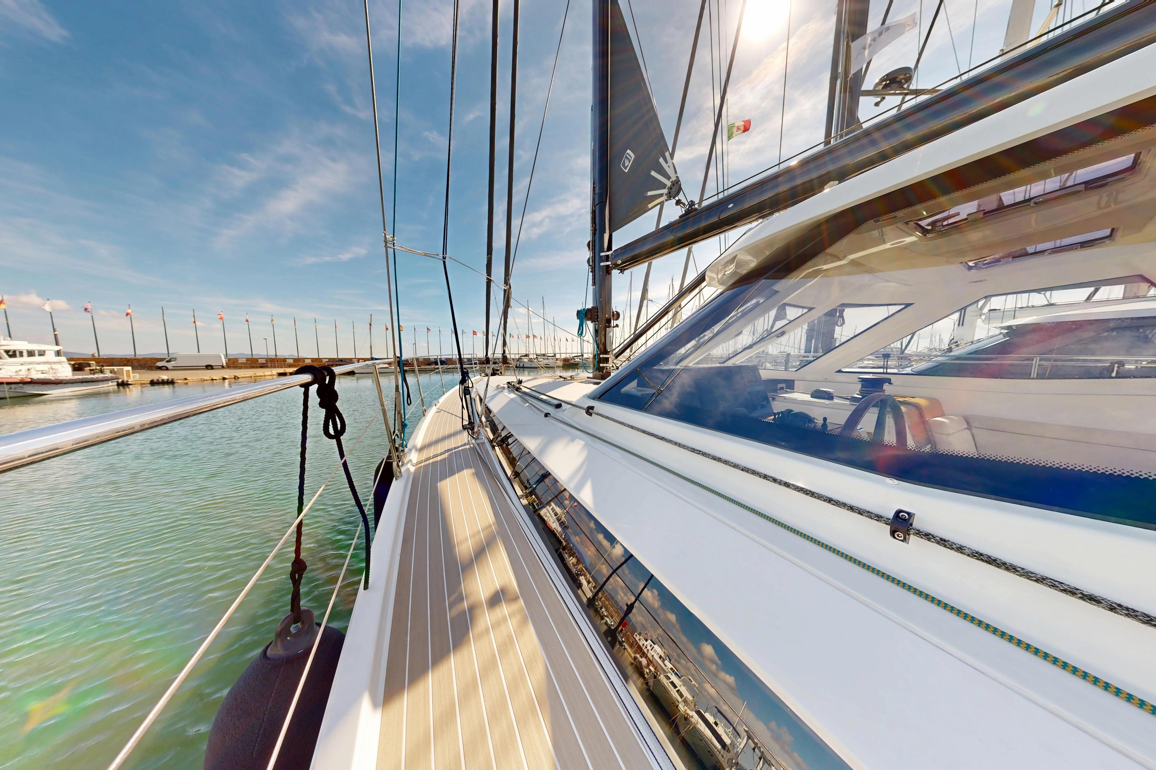 2024 Amel 60 yacht docked in a marina, showcasing sleek design and modern features.