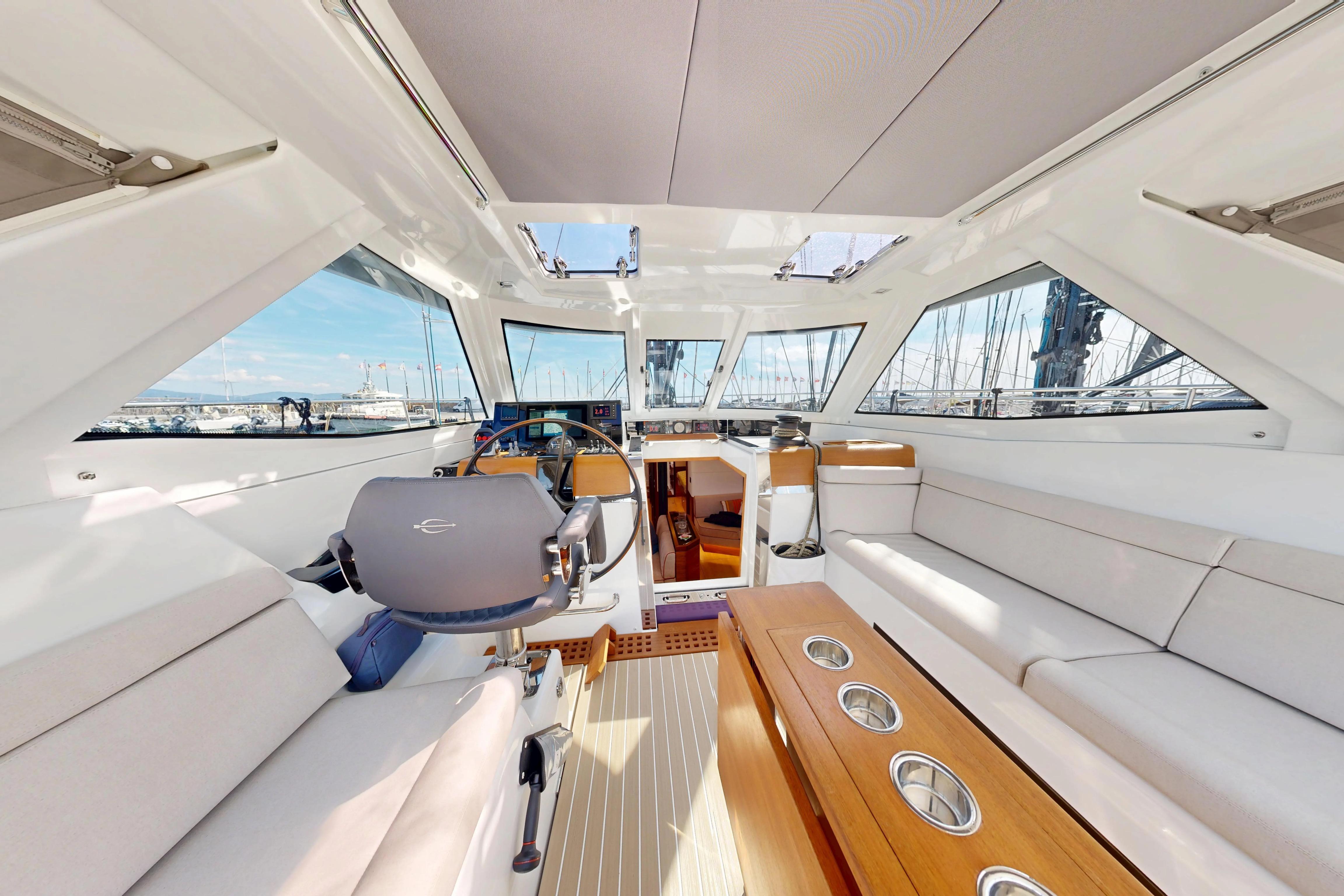 Luxurious interior of 2024 Amel 60 yacht with modern helm and seating area.